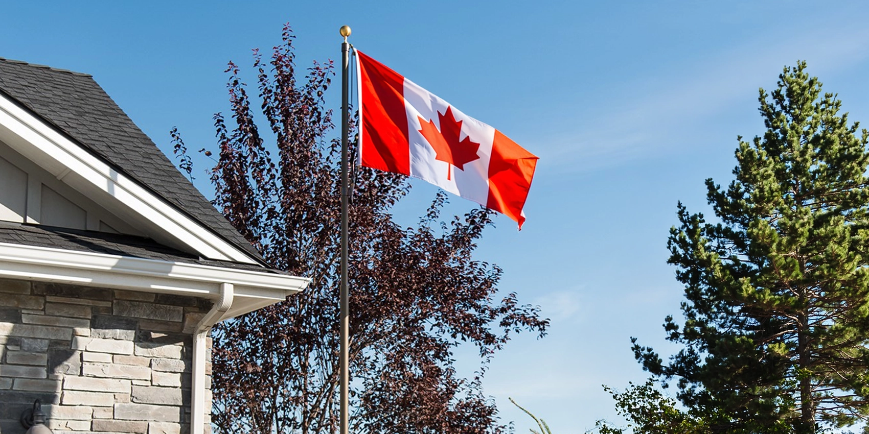 A Canadian flag flying on a Titan telescopic flagpole with a bronze anodized aluminum finish.
